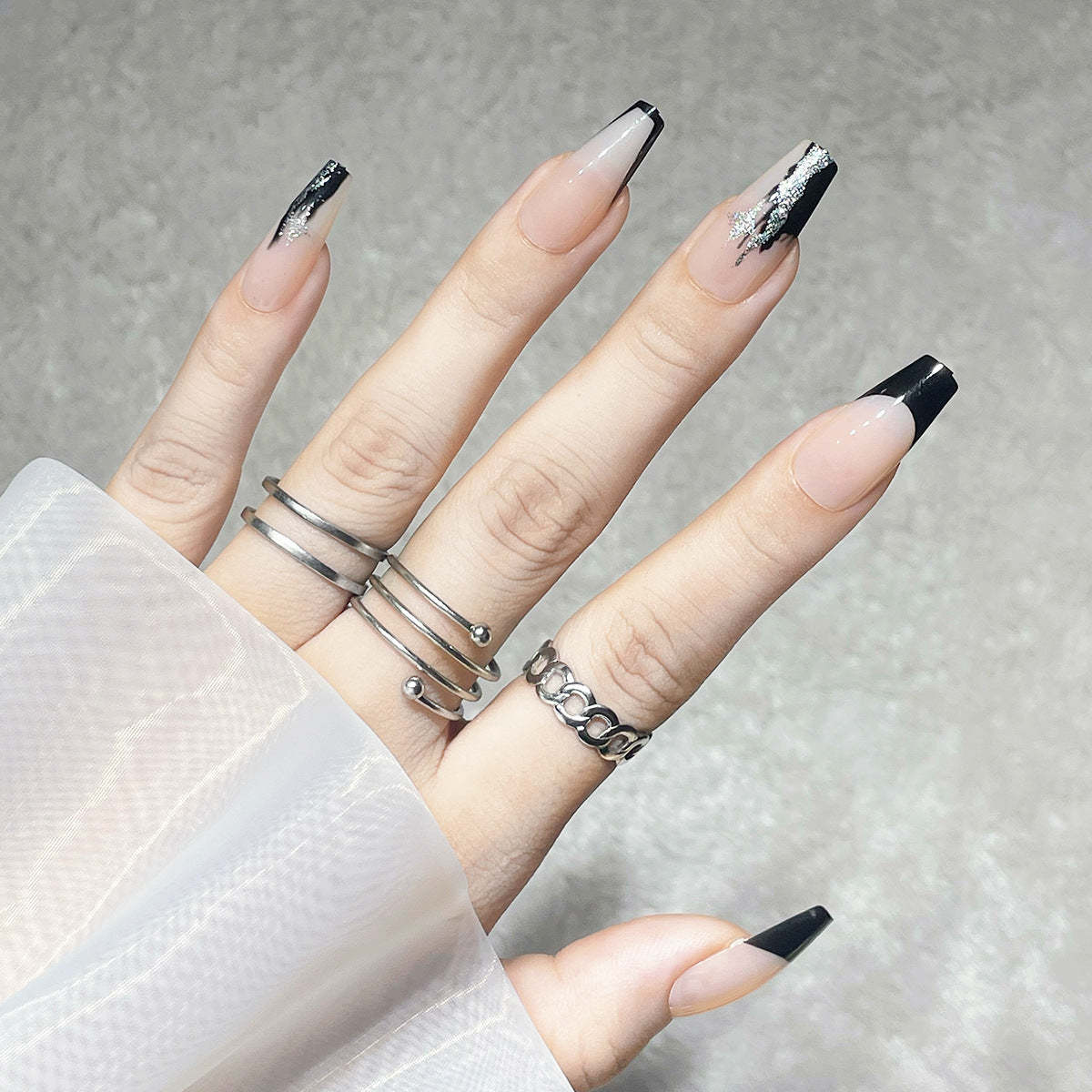 Elegante Stiletto Press-On Nägel mit künstlerischen schwarzen Spitzen und silbernen Akzenten Brehn