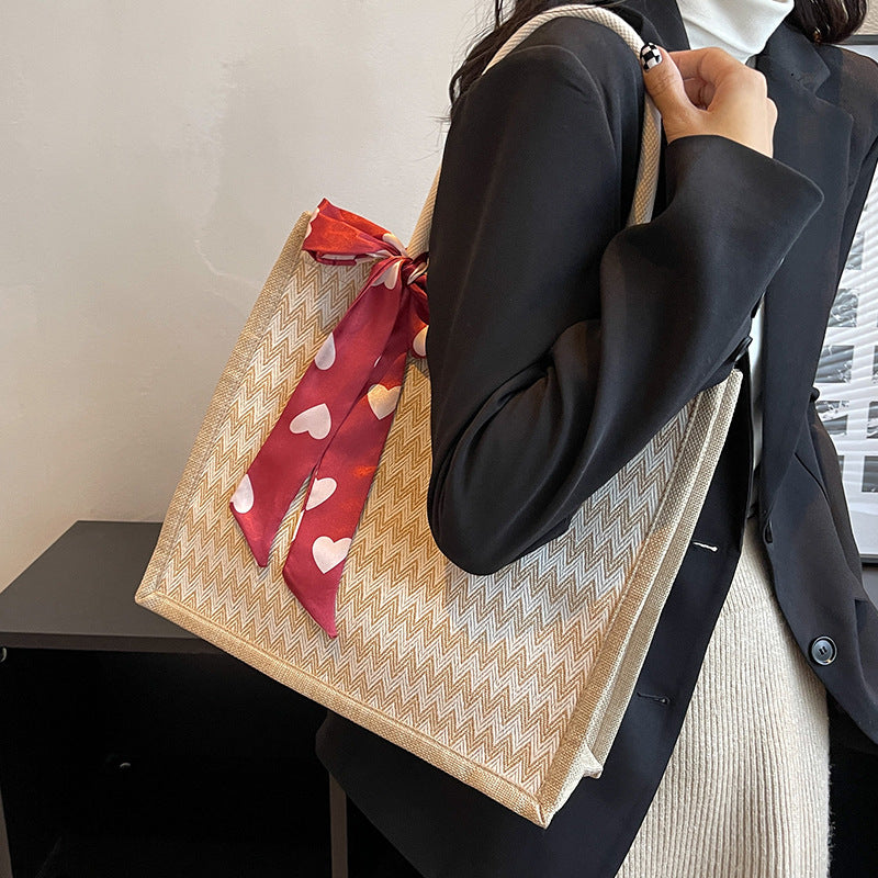 Texturierte Handtasche mit dekorativem Schal