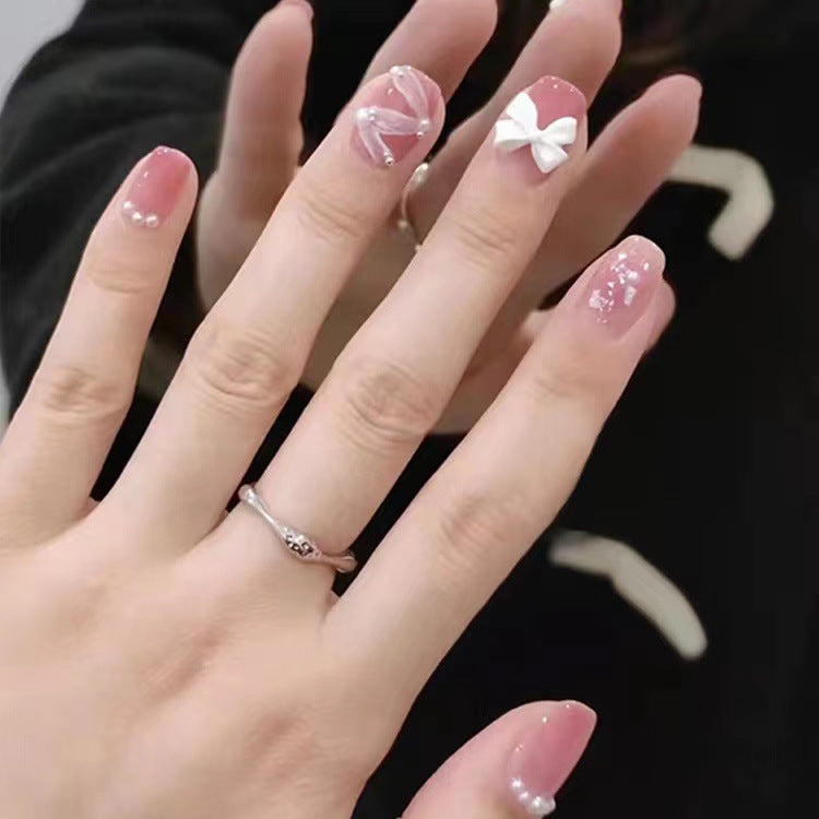 Glamouröse Nagelkunst mit Perlen- und Schleifenakzenten Brehn