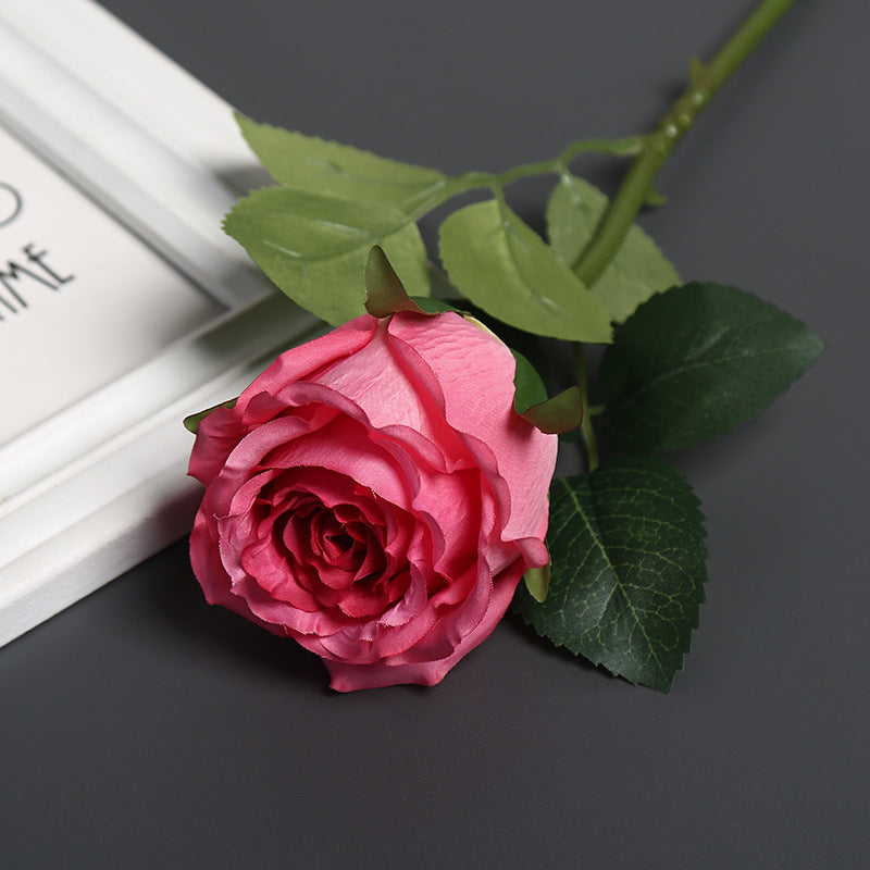 Realistische Seidenrose mit Grünanlagen