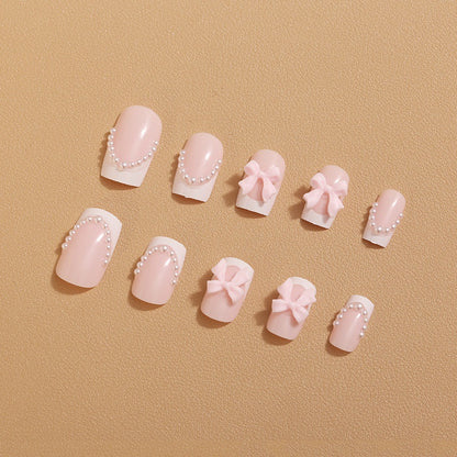 Künstliche Nagelspitzen mit eleganten Schleifen und Perlenverzierungen Brehn