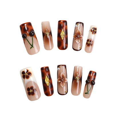 Elegantes Nagelkunstset mit floralen und goldenen Akzenten Brehn