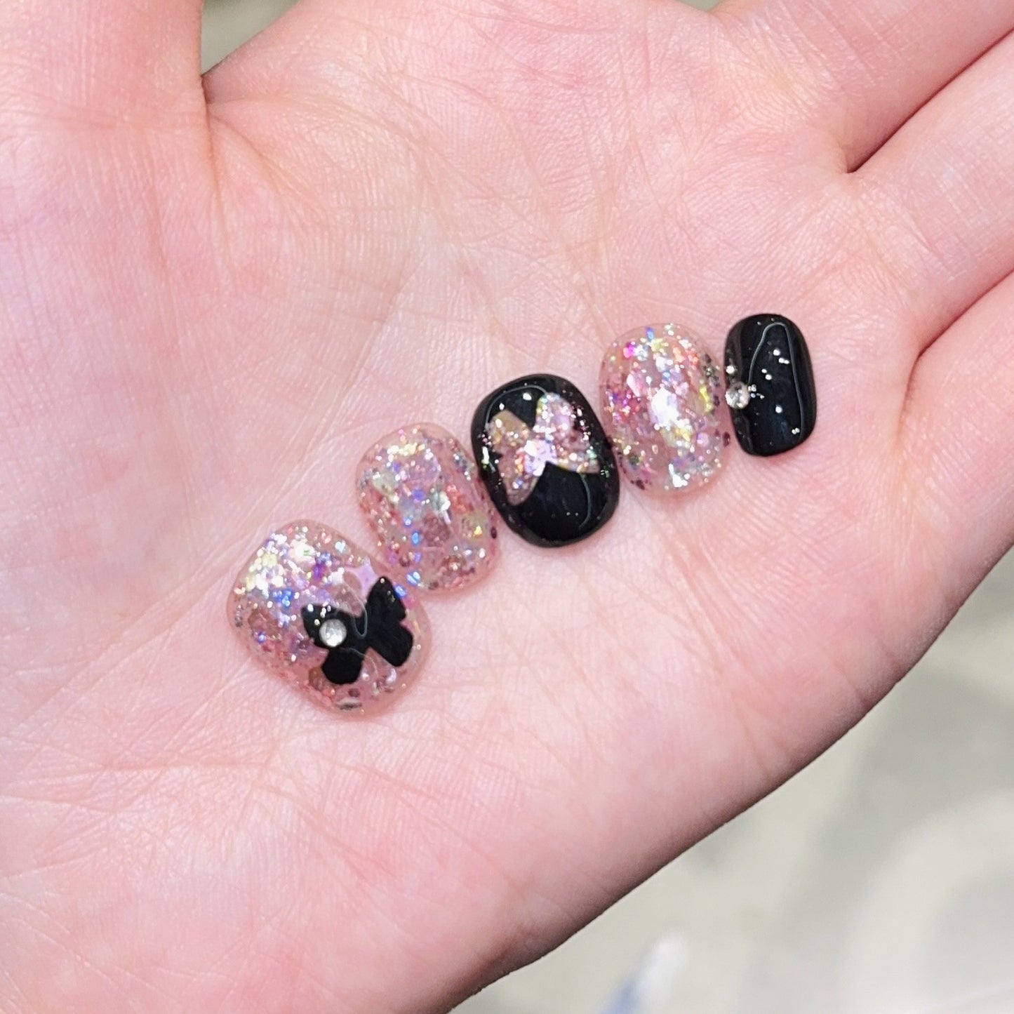 Kunstnägel mit Glitter- und Schleifenakzenten Brehn
