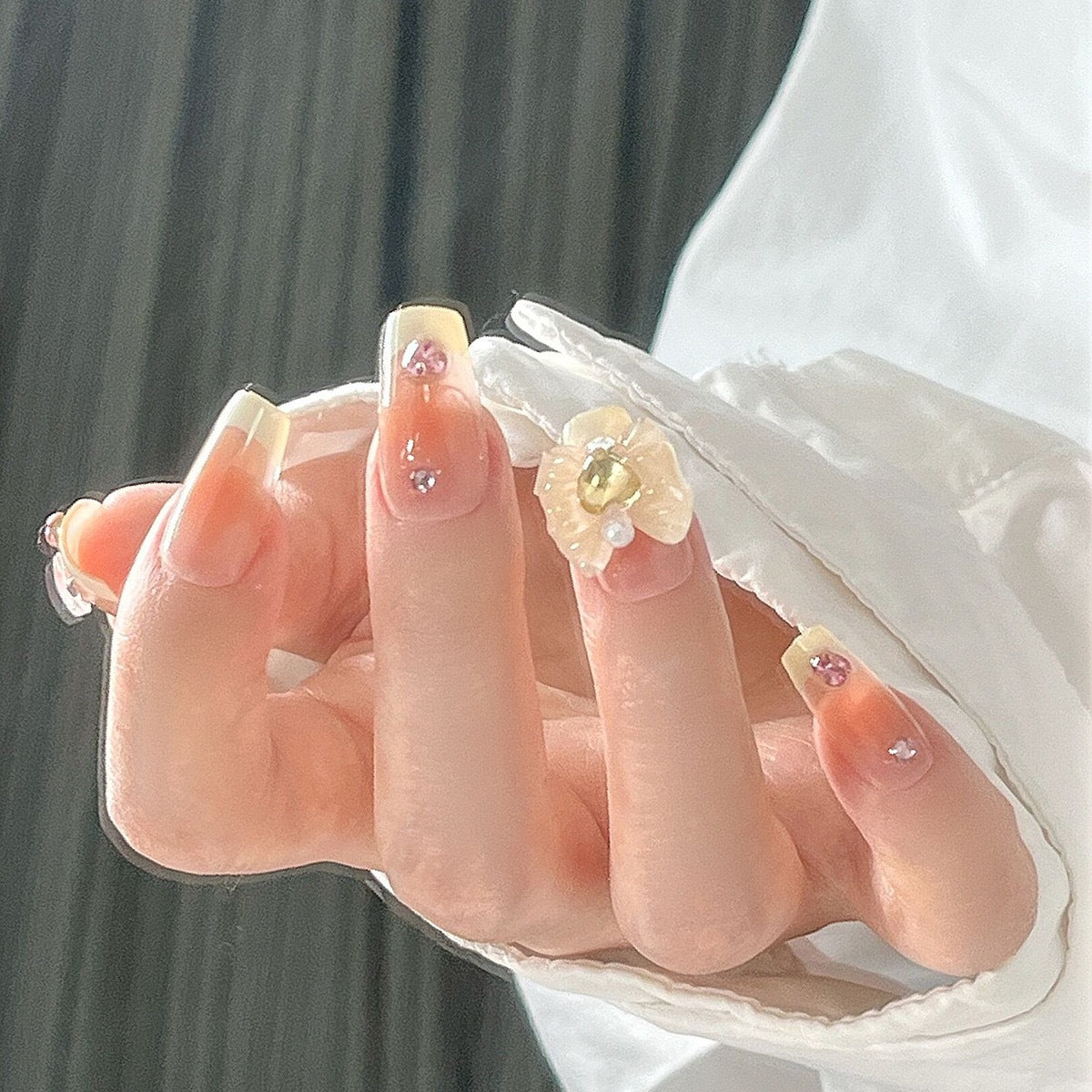 Kunstnagelset mit eleganten Blütenverzierungen und Glitzerakzenten Brehn