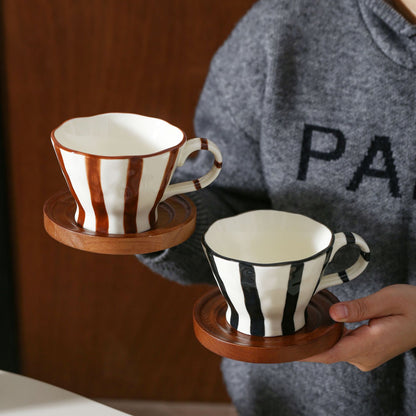 Skulpturale Keramik-Kaffeetasse mit geschwungenem Rand und markantem Streifendekor