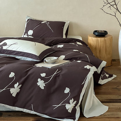 Wendbare Baumwollsatin-Bettwäschegarnitur mit floralem Silhouetten-Print und kontrastierender Kederkante