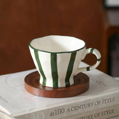Skulpturale Keramik-Kaffeetasse mit geschwungenem Rand und markantem Streifendekor