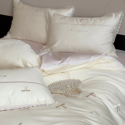Elegante Bettwäschegarnitur aus seidig-feinem Satin mit bestickten Schleifen und Spitzenbordüre