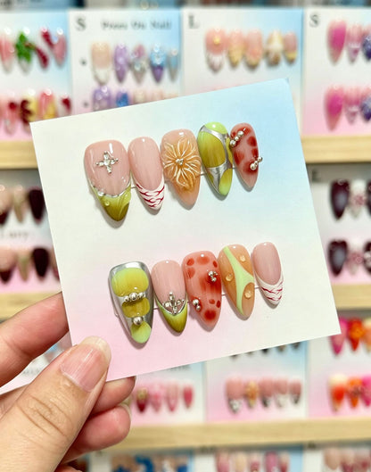 Künstlerisches Press-On-Nagelset mit dekorativen floralen und Juwelenelementen
