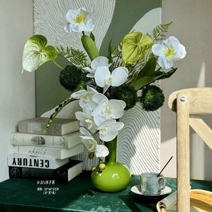 Künstliches Blumenarrangement mit dekorativer grüner Vase