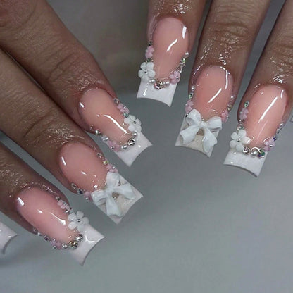 Kunstnagelset mit eleganten Schleifen und Glitzerakzenten Brehn