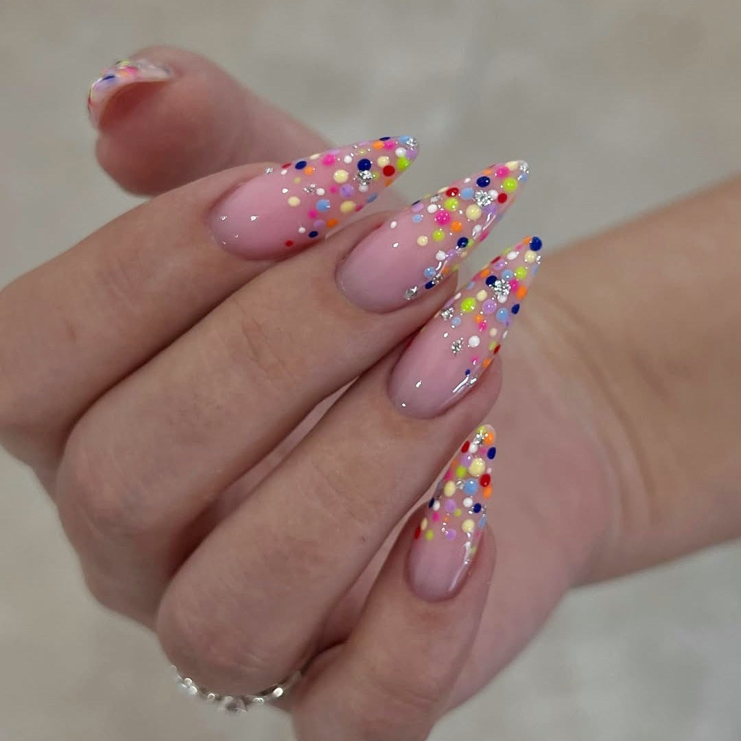 Kunstnagelset mit bunten Glitzerpunkten und eleganten Spitzen Brehn