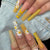 Kunstnagelset mit bunten Sonnenblumenmotiven und glitzernden Akzenten Brehn