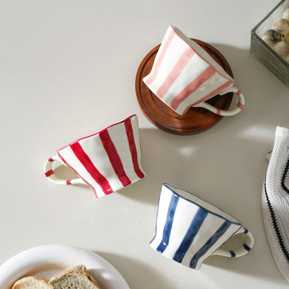 Skulpturale Keramik-Kaffeetasse mit geschwungenem Rand und markantem Streifendekor