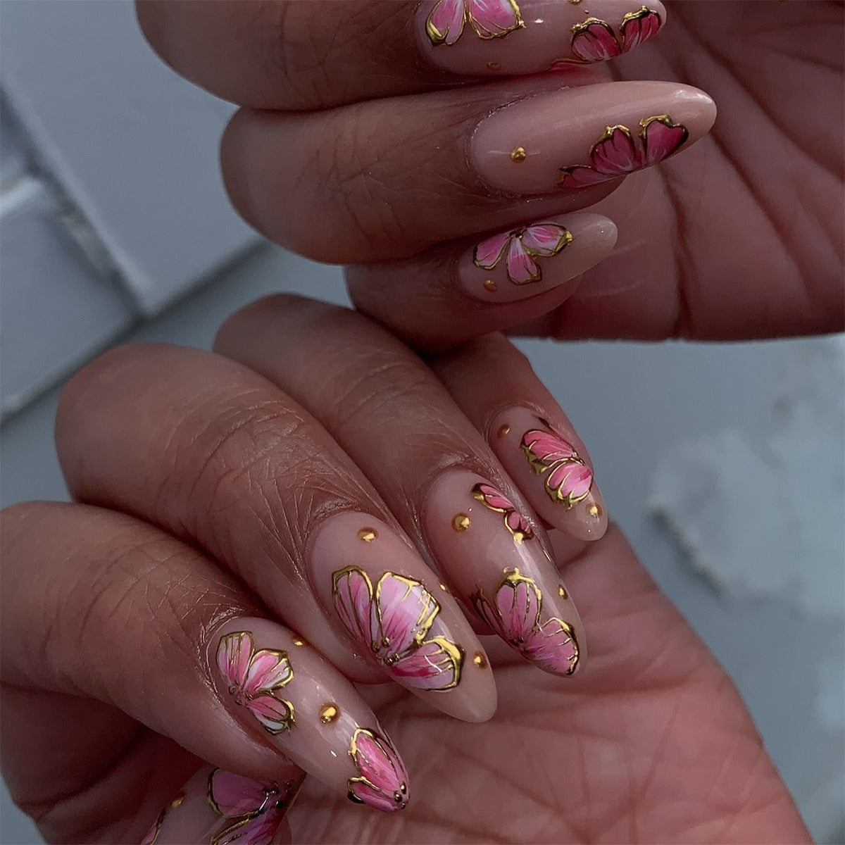 Kunstvolle Nagelkunst mit eleganten Blütenmotiven und Goldakzenten Brehn