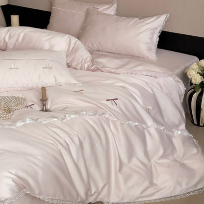 Elegante Bettwäschegarnitur aus seidig-feinem Satin mit bestickten Schleifen und Spitzenbordüre