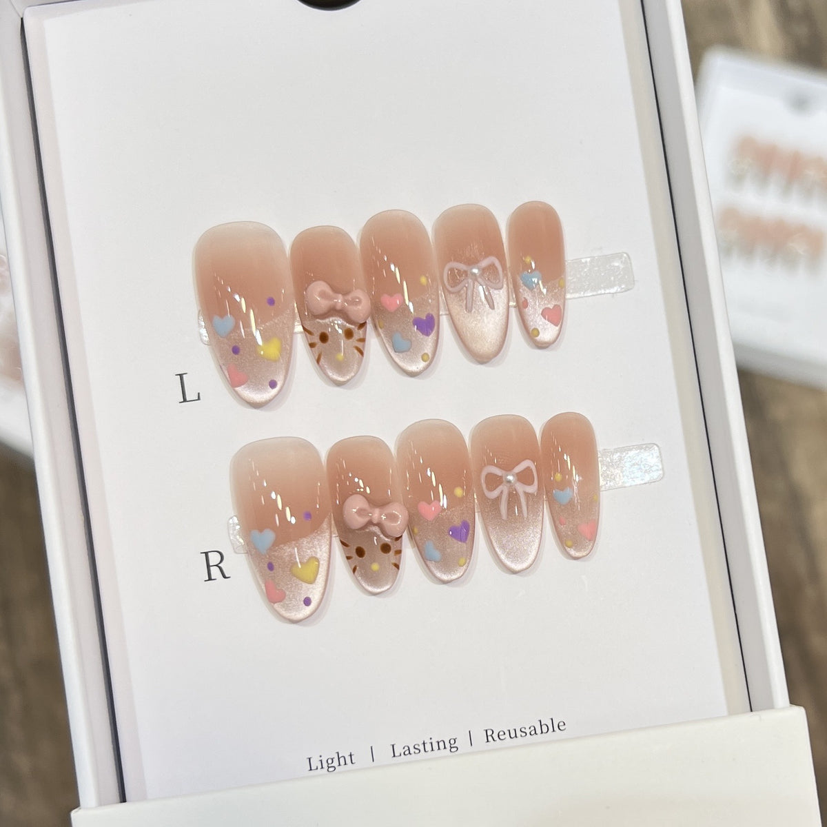 Dekorativer Press-On Nail Set mit bunten Herz- und Schleifendekoren Brehn