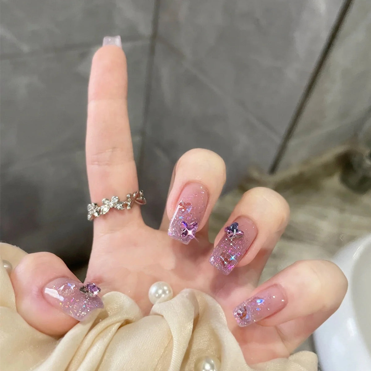 Glamouröse Kunstnägel mit Glitzer und floralen Akzenten Brehn