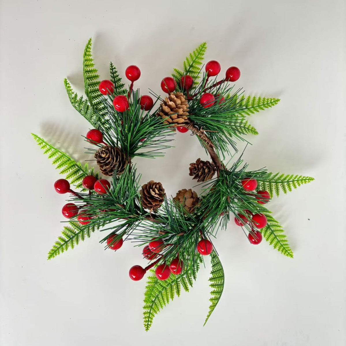 Weihnachtskranz mit Tannenzapfen und roten Beeren