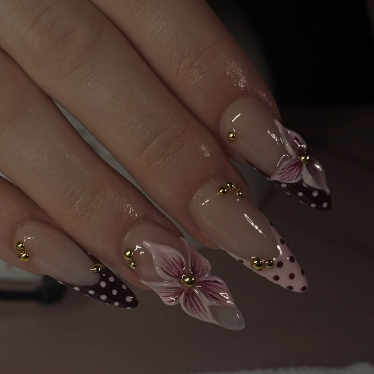 Kunstvolle Stiletto-Nägel mit floralen Akzenten und Glitzer Brehn