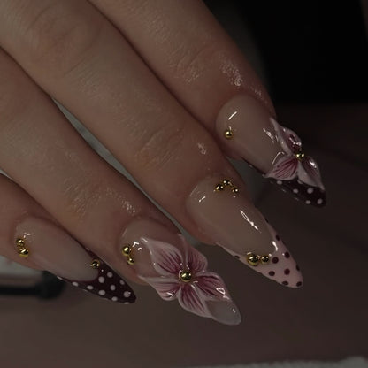Kunstvolle Stiletto-Nägel mit floralen Akzenten und Glitzer Brehn