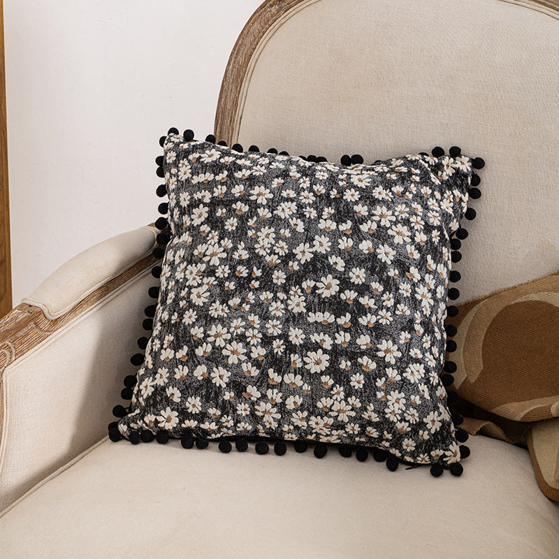 Dekoratives Wurfkissen mit floralen Pom-Poms