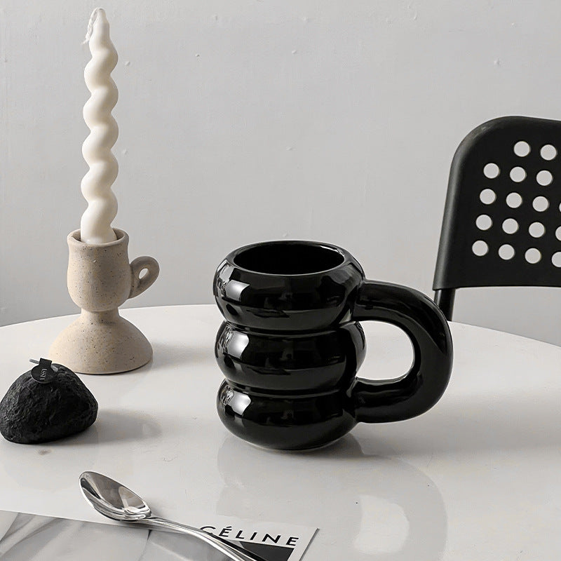 Skulpturaler Keramik-Kaffeebecher mit gestapeltem Ringkörper und ergonomischem Griff