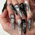 Kunstnagelset mit eleganten geometrischen Designs und kreativen Metallic-Akzenten Brehn