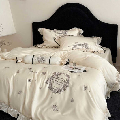Luxuriöse Satin-Bettgarnitur mit floraler Stickbordüre und Volant