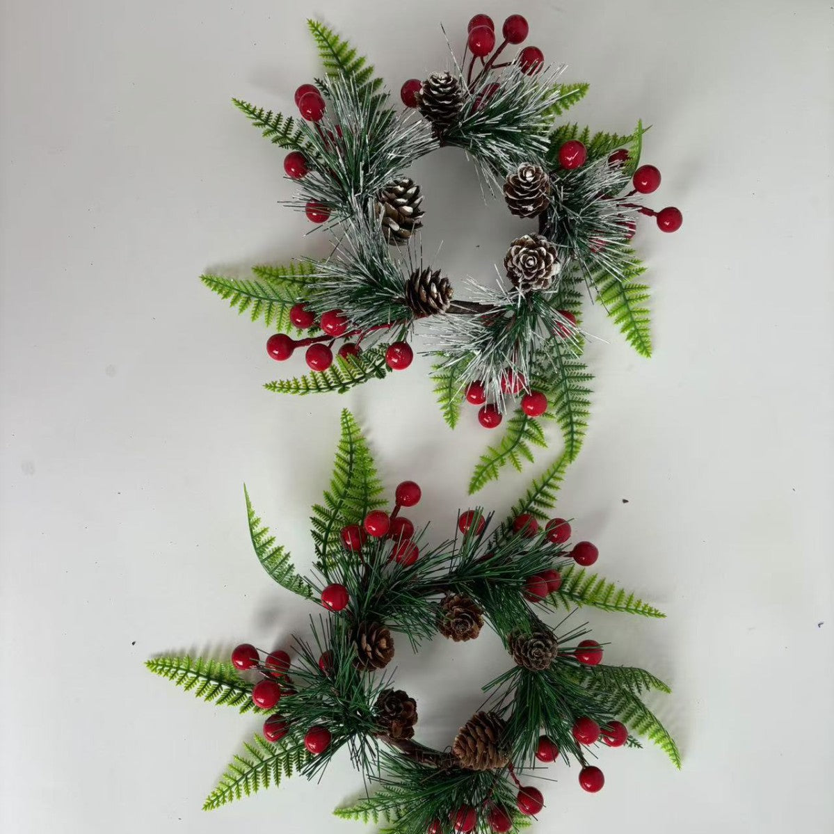 Weihnachtskranz mit Tannenzapfen und roten Beeren