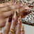 Dekoratives Press-On Nagelkunstset mit floralen und goldenen Akzenten Brehn