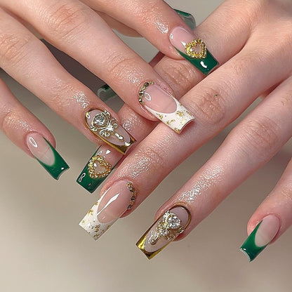 Exquisite Kunstnägel mit Goldverzierungen und Glitzerakzenten Brehn