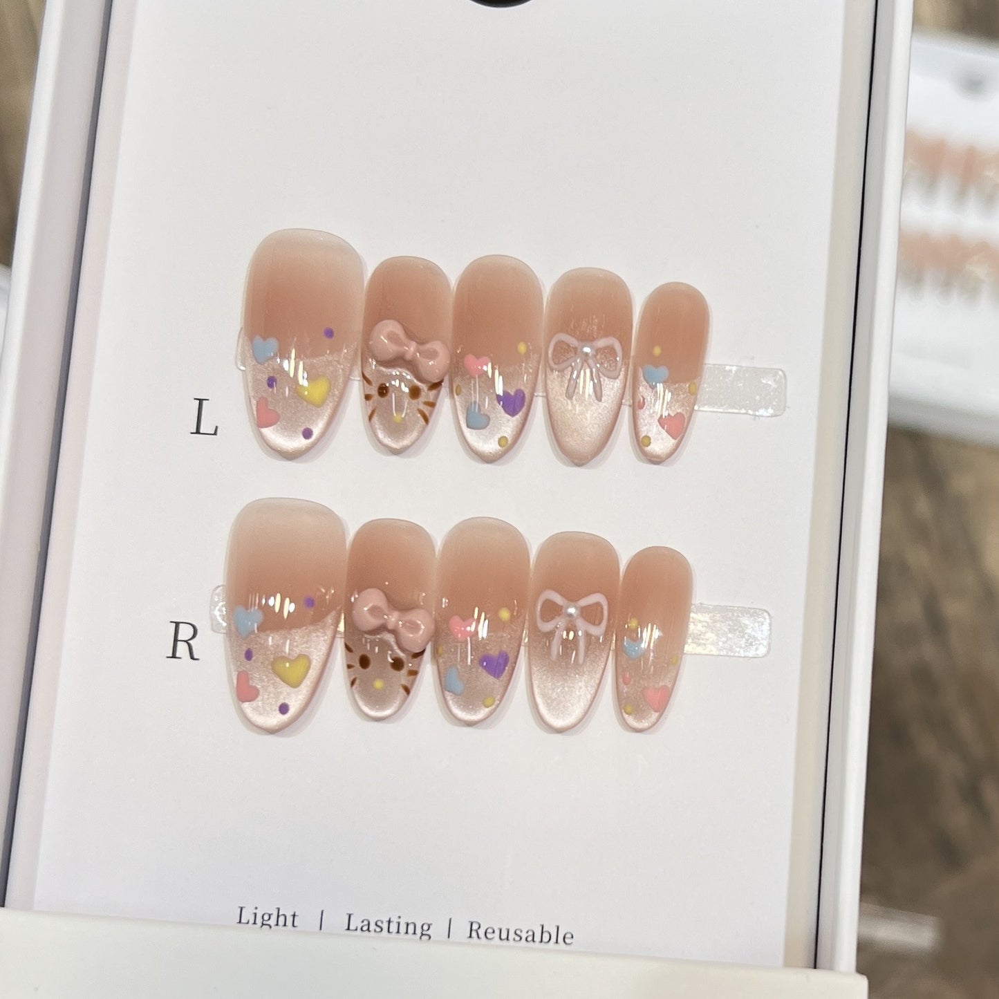 Dekorativer Press-On Nail Set mit bunten Herz- und Schleifendekoren Brehn