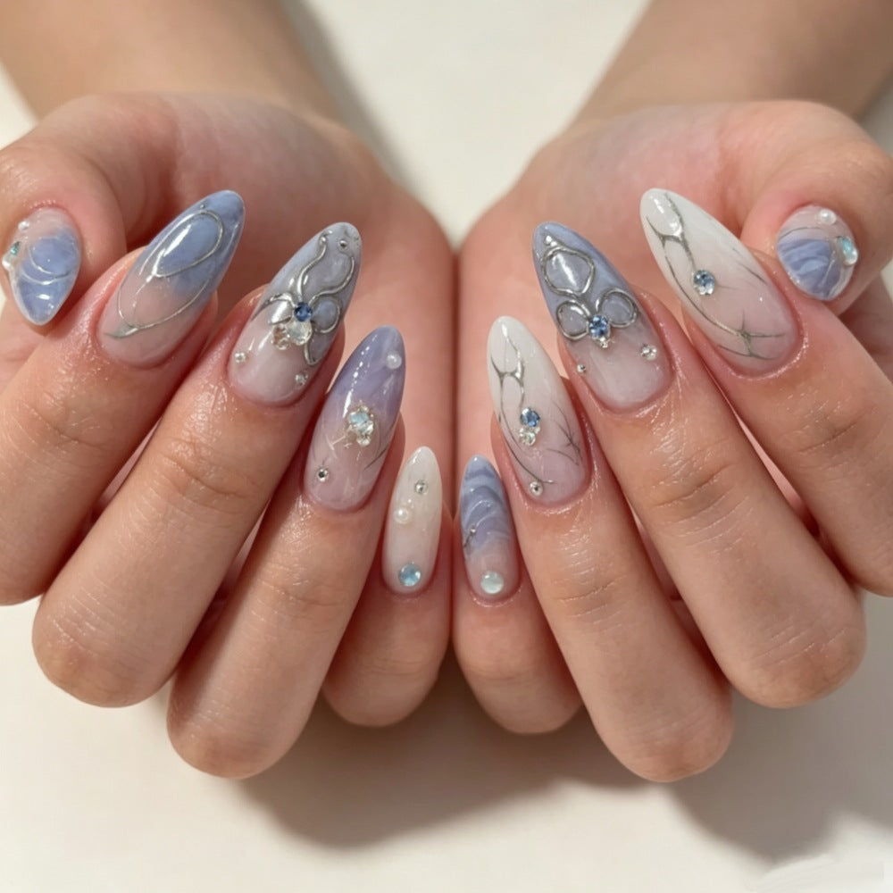 Künstlerisches Press-On-Nageldesign mit floralen und Schmuckakzenten Brehn