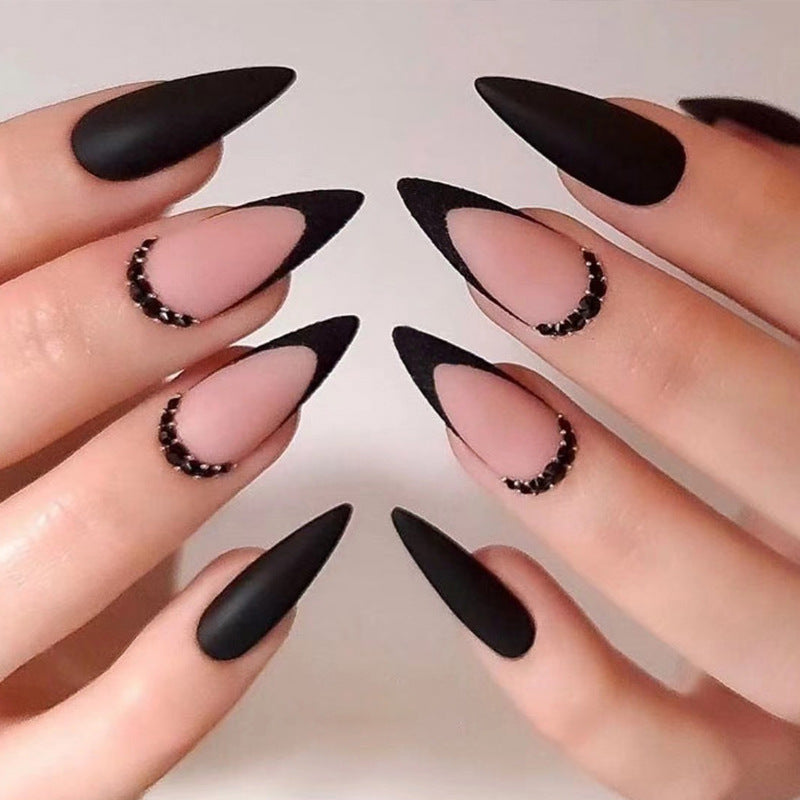 Kunstvolle Stiletto-Nägel mit elegantem Schwarz-Design und Glitzerakzenten Brehn