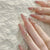 Kunstnagelset mit eleganten Spitzen und glamourösen Strassakzenten Brehn