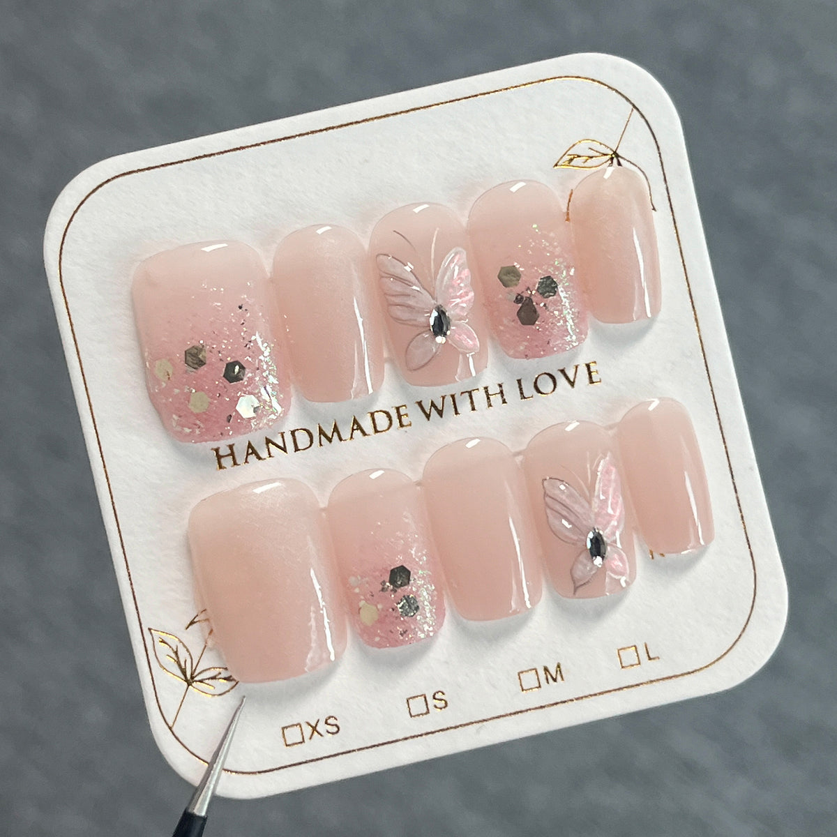 Kunstvolle Nagelkunst mit Schmetterlingsmotiven und Glitzerakzenten Brehn