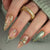 Kunstnagelset mit luxuriösen Blütenapplikationen und Glitzerakzenten Brehn