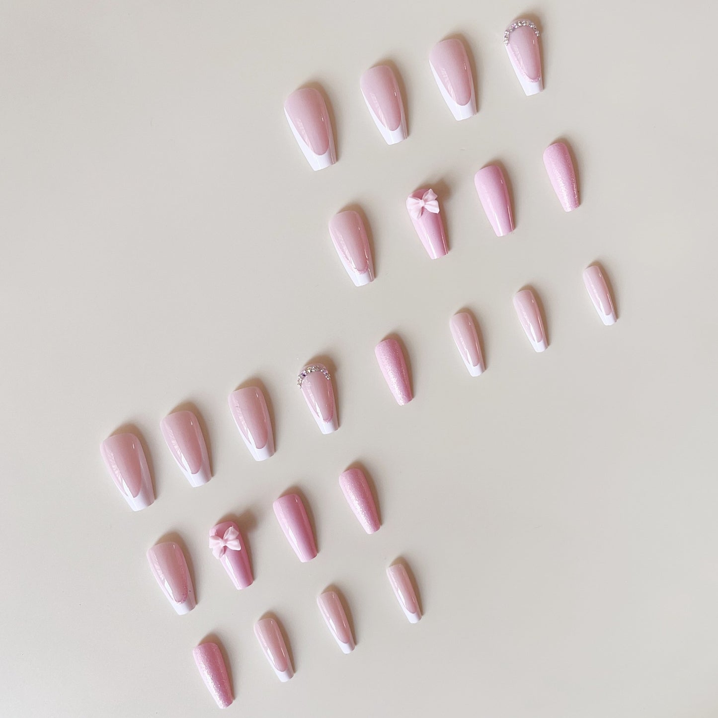 Kunstnagelset mit verspielten Schleifen und Glitzerakzenten Brehn
