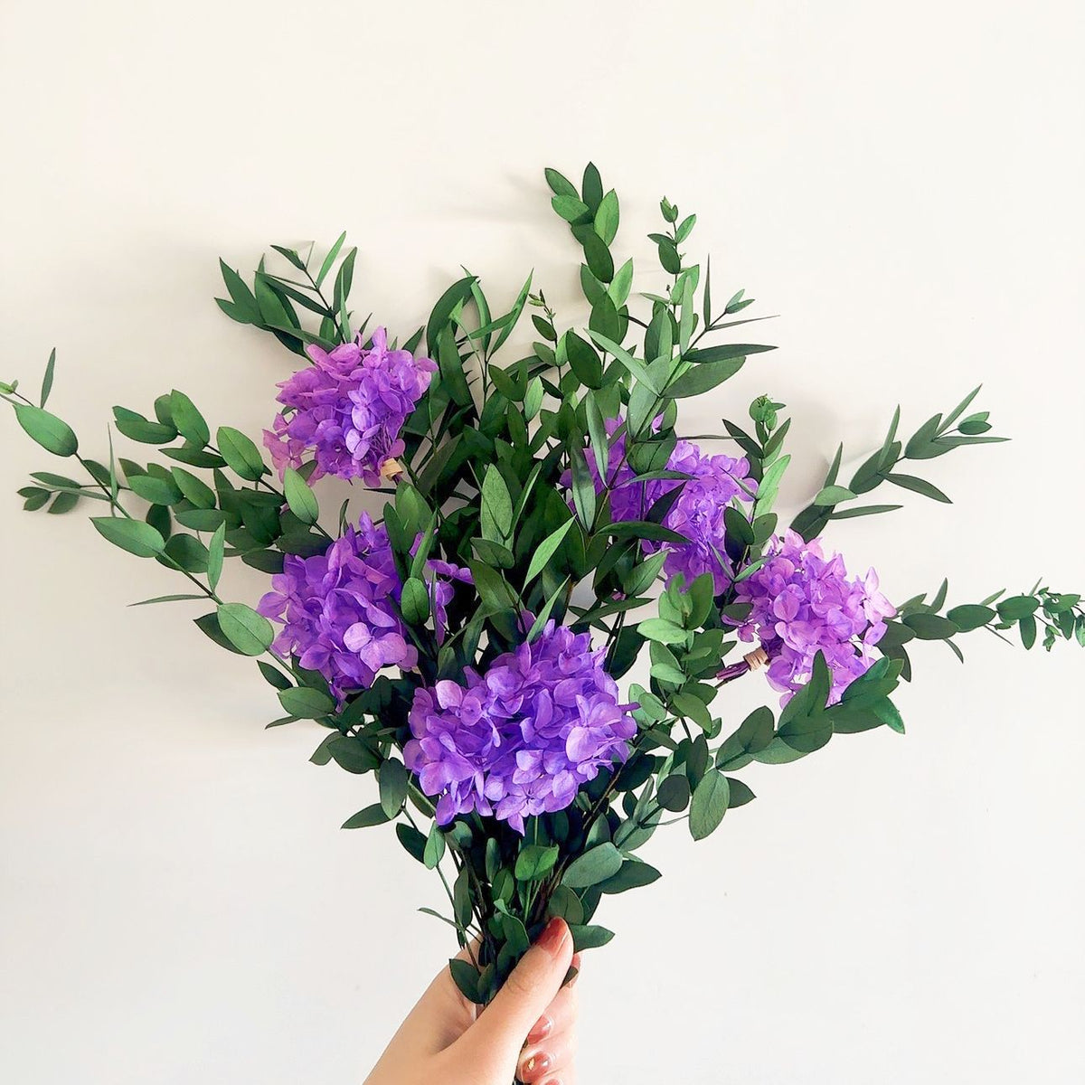 Lebensechter Blumenstrauß mit grünen Blättern