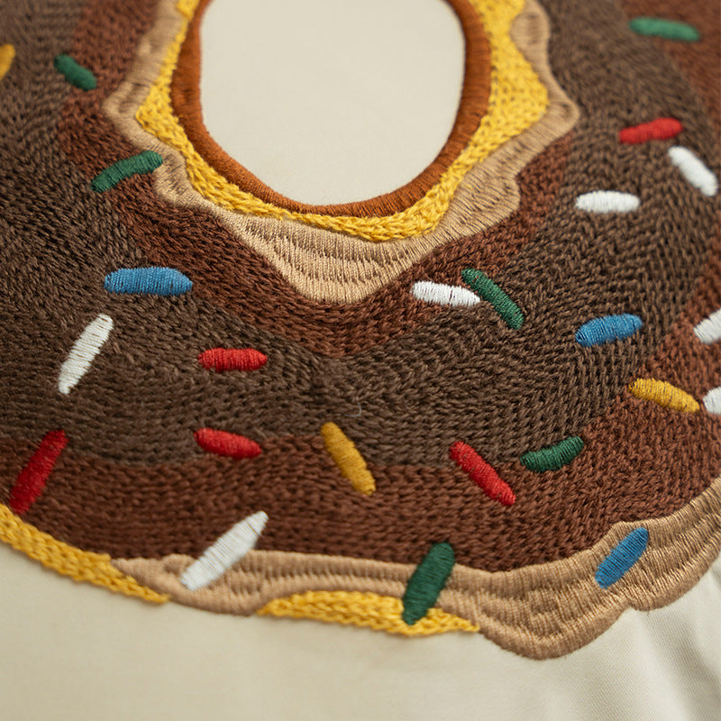 Quadratischer dekorativer Kissenbezug mit handgestickter Donut‑Applikation und Keder Brehn