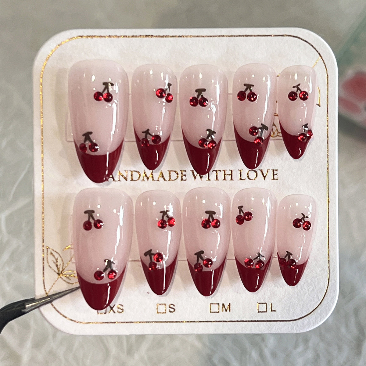 Kunstvolle Stiletto-Nägel mit Kirschmotiven und Glitzerakzenten Brehn