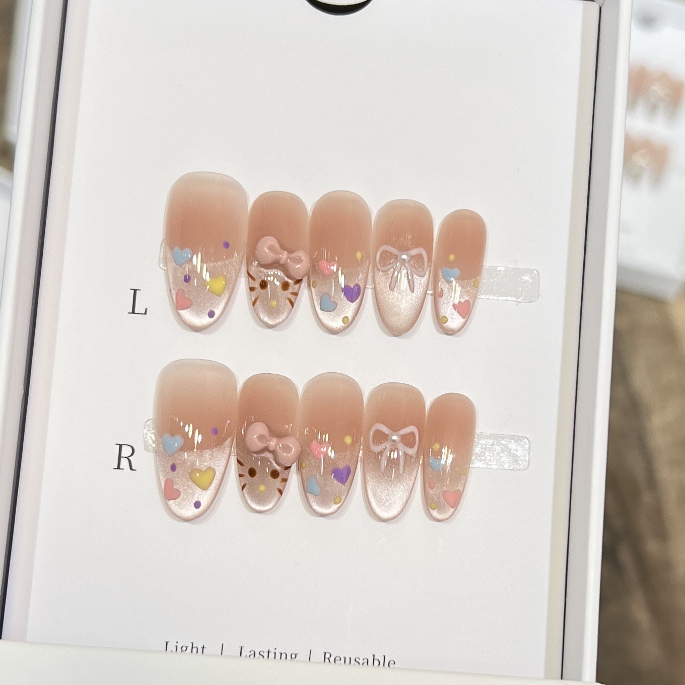 Dekorativer Press-On Nail Set mit bunten Herz- und Schleifendekoren Brehn