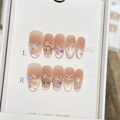 Dekorativer Press-On Nail Set mit bunten Herz- und Schleifendekoren Brehn