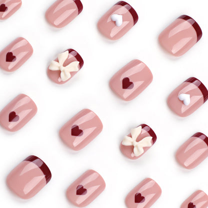 Kunstvolle Nagelkunst mit Herz- und Schleifenmotiven Brehn