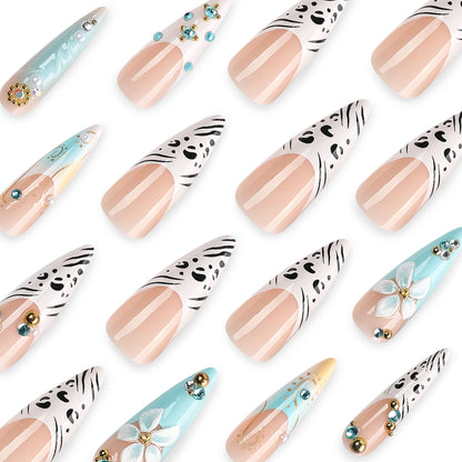 Kunstvolle Stiletto-Nägel mit floralen Akzenten und Glitzerdetails Brehn