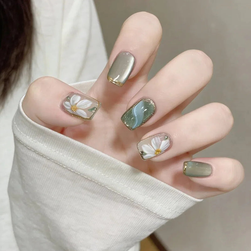 Kunstnägel mit Floralen Akzenten und Glamourösem Goldrand Brehn
