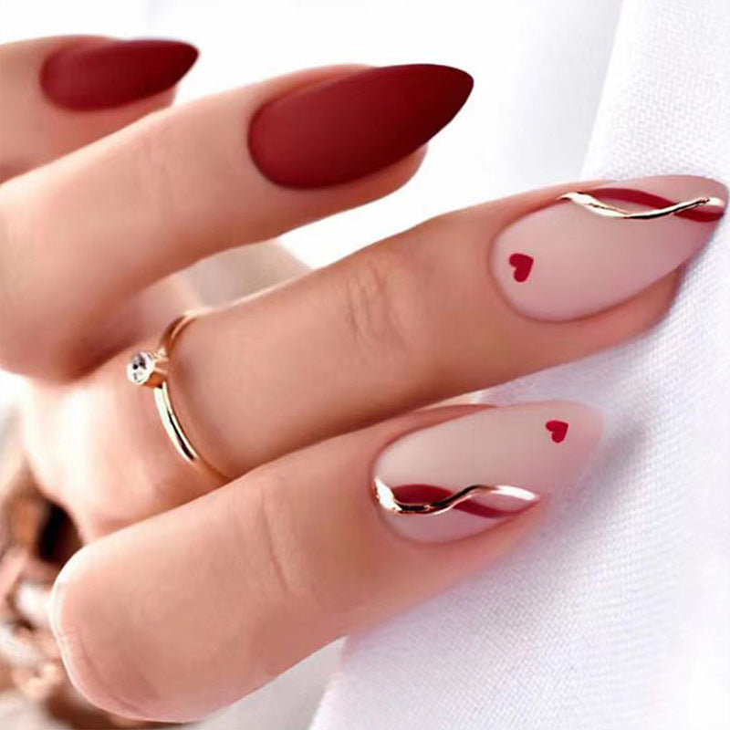 Kunstvolle Stiletto-Nägel mit herzförmigen Akzenten Brehn