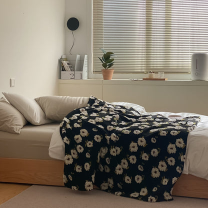 Gemusterte Wohndecke mit gewebten Blumenapplikationen