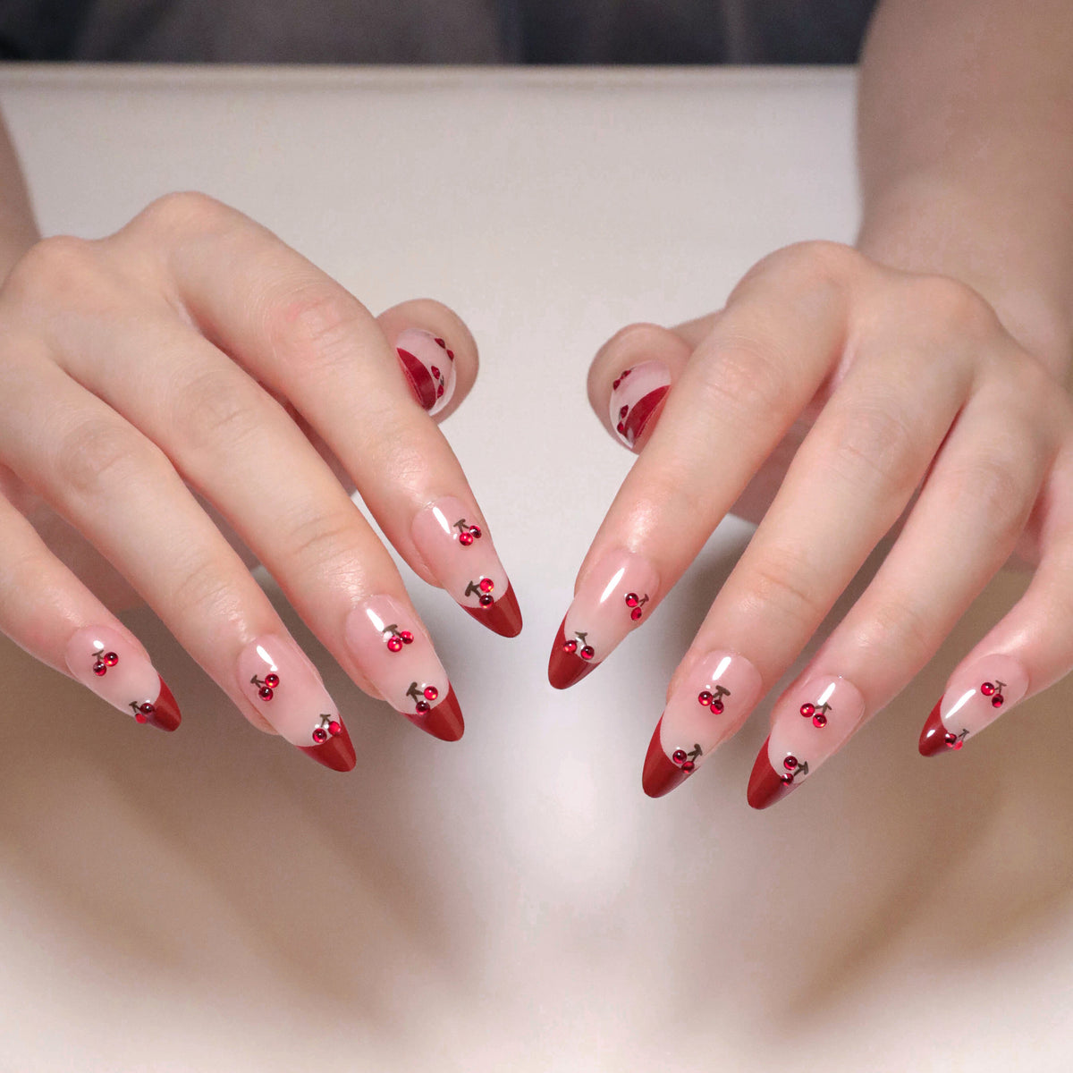 Kunstvolle Stiletto-Nägel mit Kirschmotiven und Glitzerakzenten Brehn